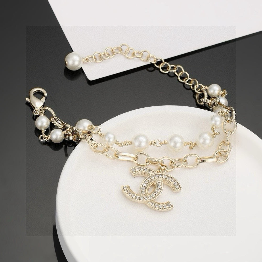 CHANEL - A FAUX PEARL CC BRACELET